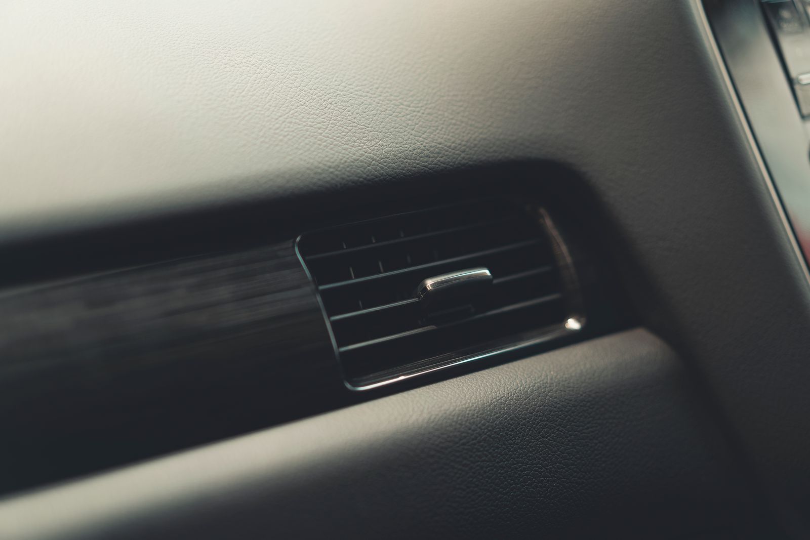 Close-up of an air conditioning vent in a car dashboard