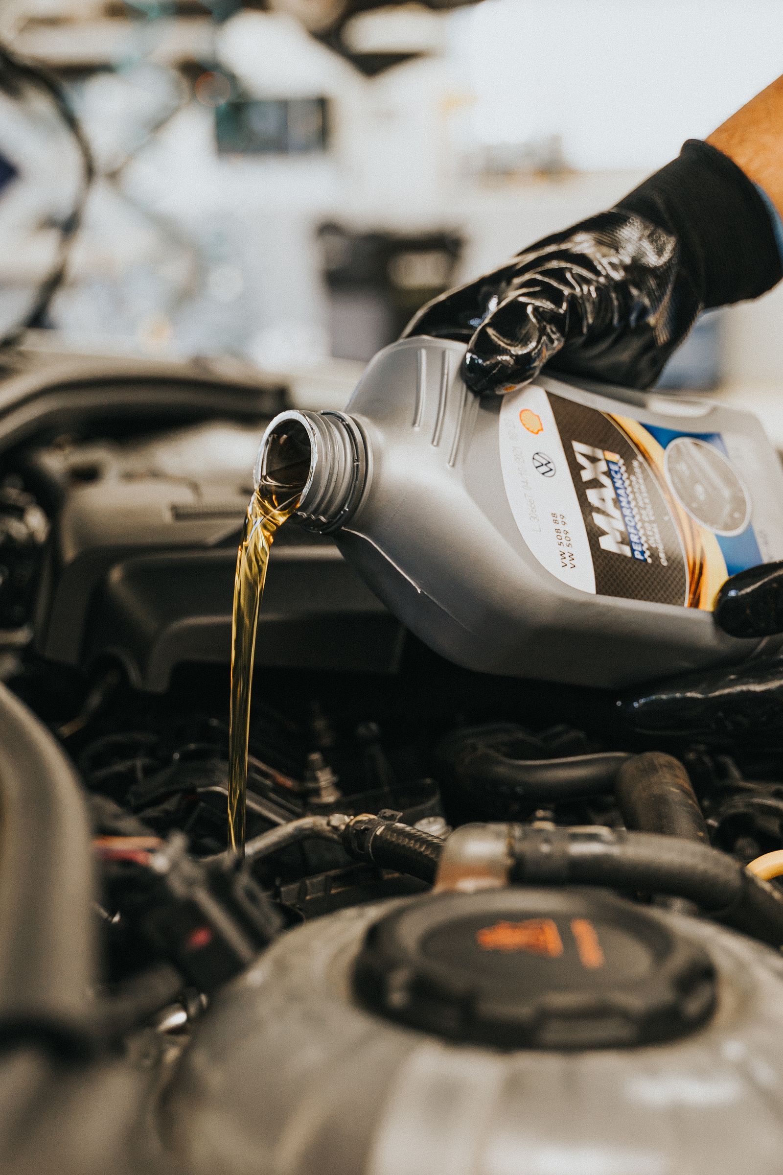Fresh engine oil being poured into an engine during a service